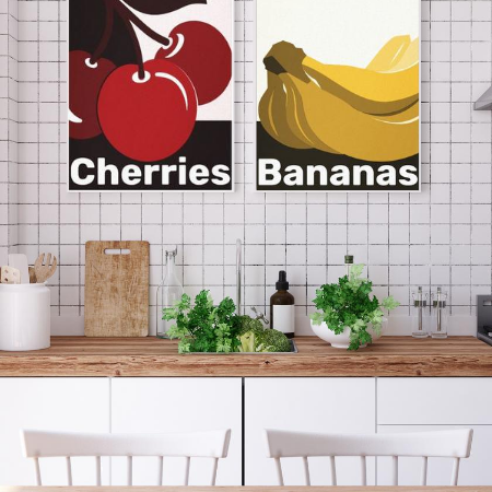 a modern white kitchen with wooden workbench showing as wall decor canvas prints of bananas and cherries, in the colors black, white,red and yellow