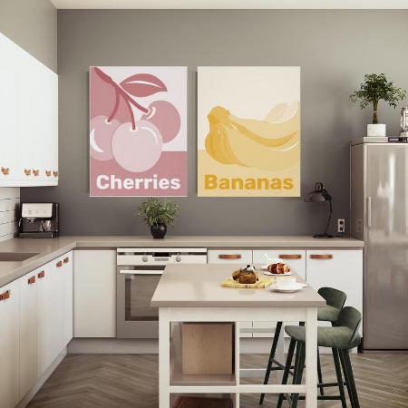 pastel kitchen wall decor showing monochrome poster prints of cherries in reddish pastel hues, and bananas in yellow pastels in a white kitchen