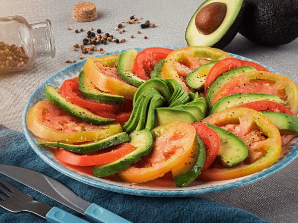 tomato and avocado salad, arranged with circular layerd alternating thin tomato and avocado slices